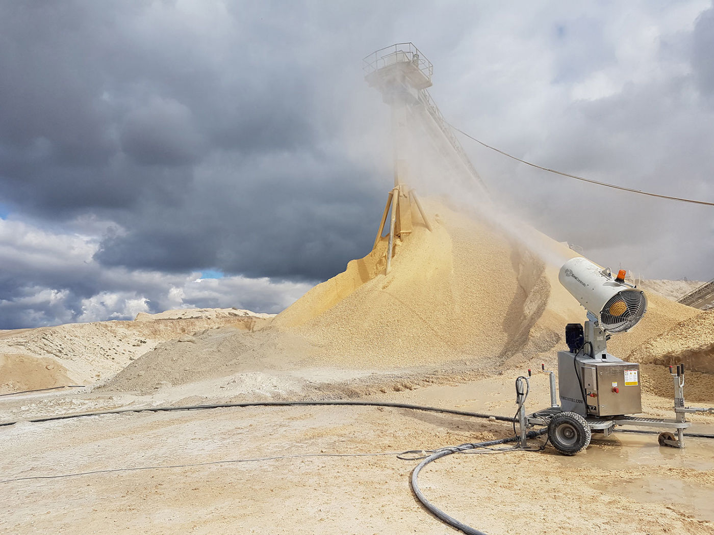 Mist cannon treating an aggregate stockpile